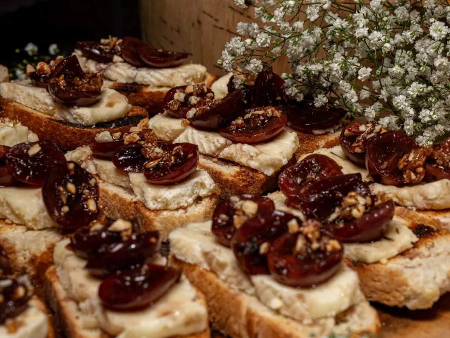 Bocas de pan con carne y tomate sobre bases de madera, con flores de nube