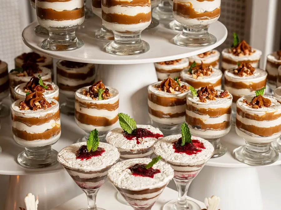 Torre de postres en copas, con crema, nueces y frutos rojos