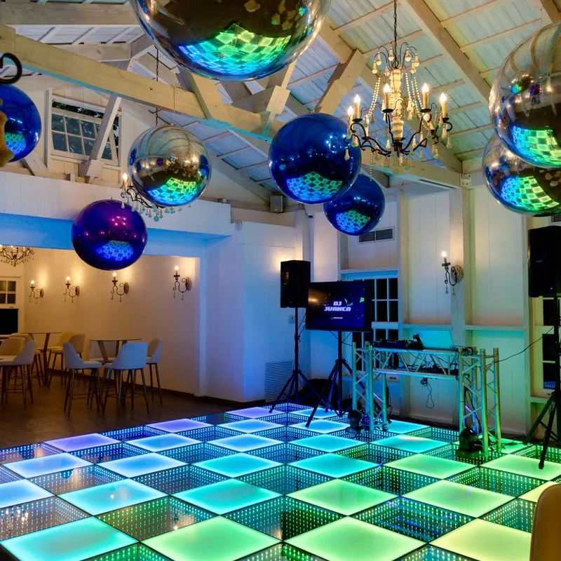 Pista de baile iluminada en colores con esferas espejadas colgando del techo